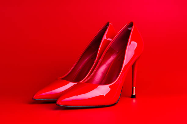 istock Red high heel women shoes on red background 1077161920