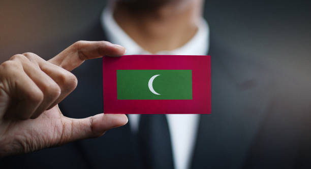 モルディブの国旗のカードを保持している実業家 - maldivian flag ストックフォトと画像