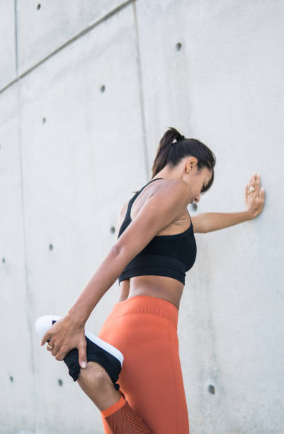 istock Young woman stretching after run in nyc 1077163692