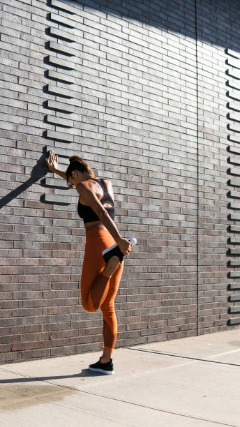 istock Young woman stretching after run in nyc 1077163802