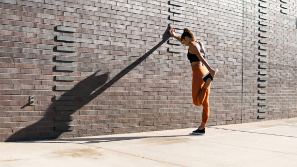 Stretching after run in New York on brick wall