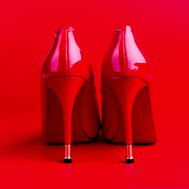 istock Red high heel women shoes on red background 1077164010