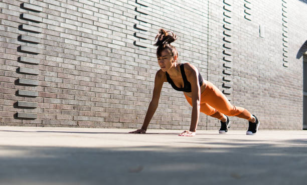 una bella donna che fa flessioni per strada di new york - abdomen abdominal muscle muscular build beautiful foto e immagini stock