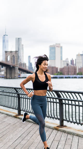 istock Young woman running over manhattan bridge 1077164060