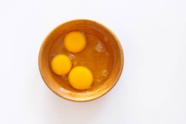 istock Egg yolks in wooden bowl on white 1077164944