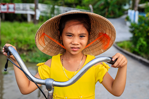 Vietnamese little girl holding a bicycle, Mekong River Delta, Vietnam