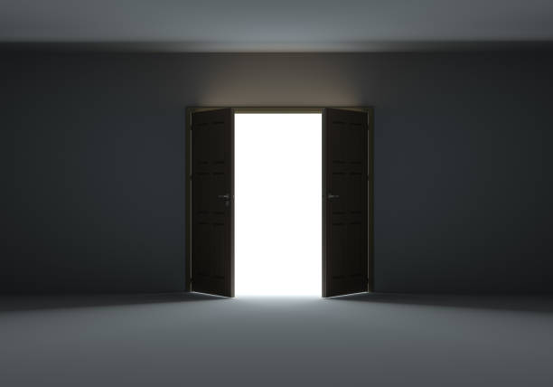 istock Doors opening to show bright light in the darkness 1077171132