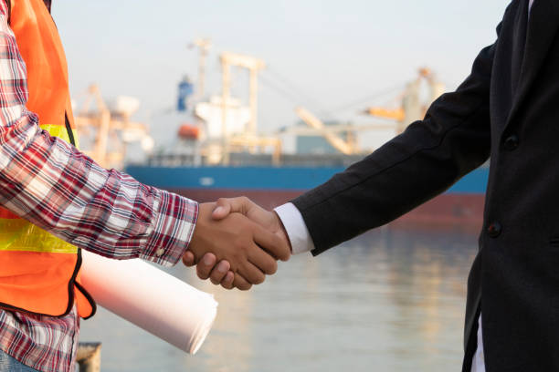 istock Young architect and civil engineer shaking hands for project success in the port 1077172554