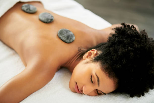 No more muscle tension Shot of an attractive young woman getting a hot stone massage at a spa hot stone massage stock pictures, royalty-free photos & images