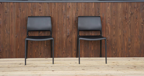 istock Black double chairs on light timber floor with dark timber background 1077175062