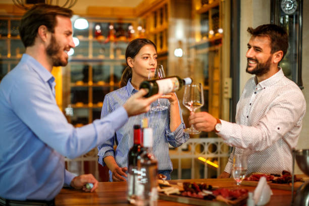 istock Sommelier presenting wines to a couple in a winery cellar 1077177178