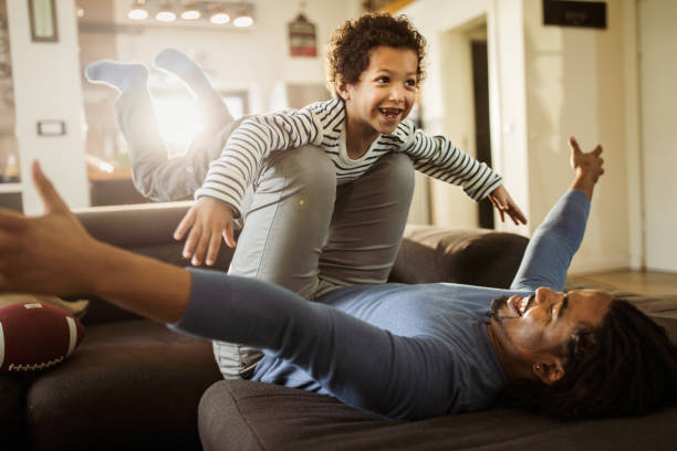 istock Joyful black boy having fun with his father at home. 1077178628