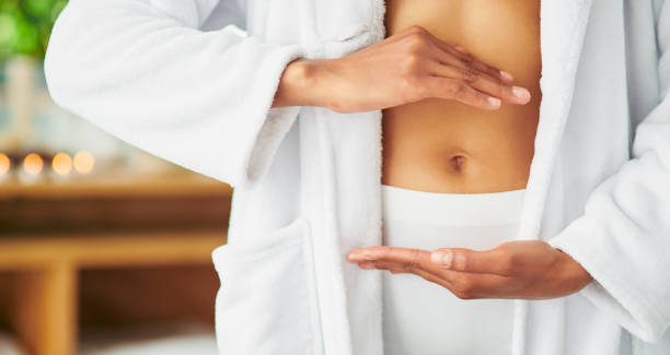 Be good to your gut Cropped shot of an unrecognizable young framing her stomach with her hands at a spa navel stock pictures, royalty-free photos & images