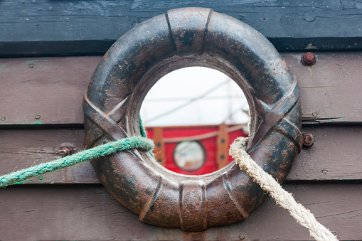Decorative hole for mooring ropes in the board of an old wooden ship