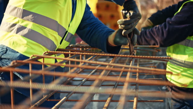 Two builders tying rebars together
