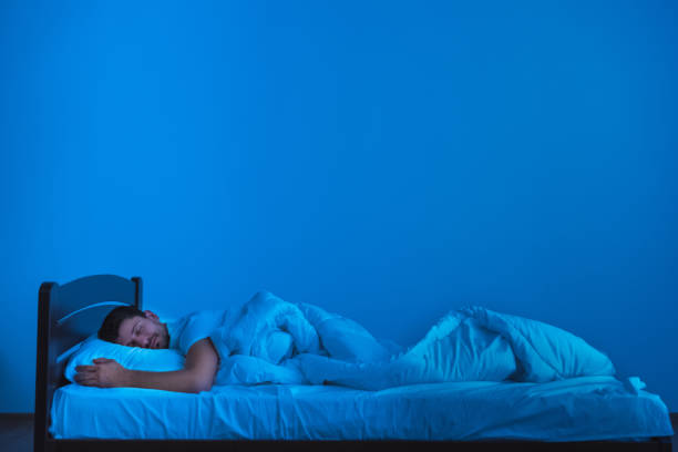 istock The man sleeping on the bed. evening night time 1077191002