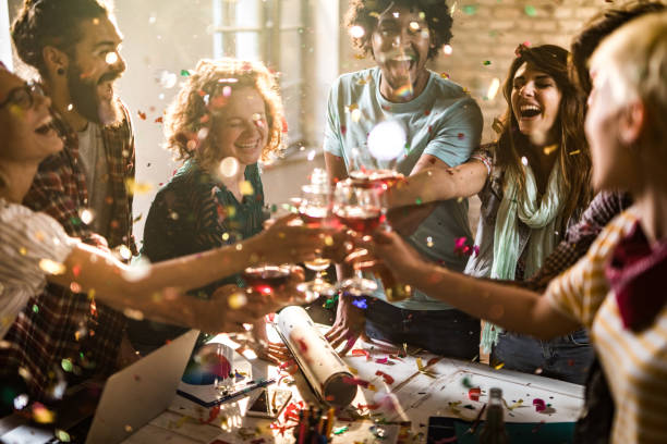 Large group of happy entrepreneurs toasting at office party. Group of happy freelancers having fun while toasting with alcohol on a party in the office. office parties stock pictures, royalty-free photos & images