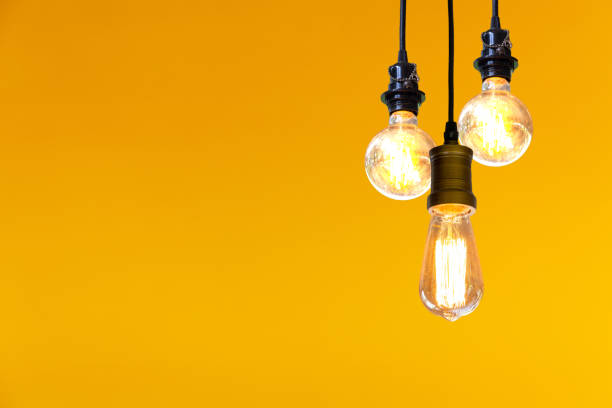 istock Vintage light bulb hanging over yellow background, Idea concept. 1077201364