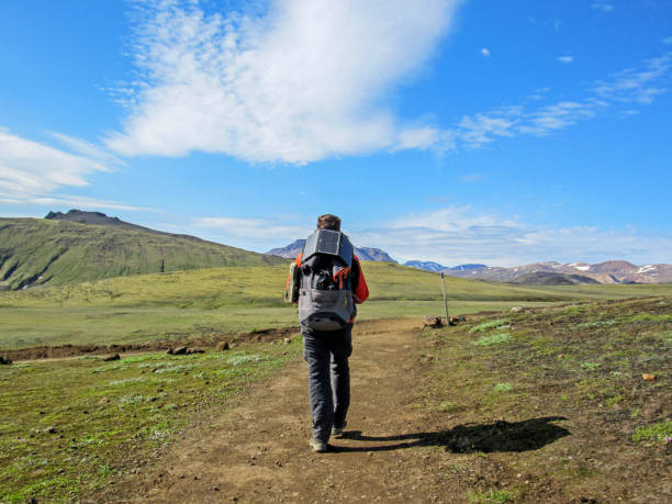 istock Male traveler from back in the mountains with big backpack and solar panel 1077204384