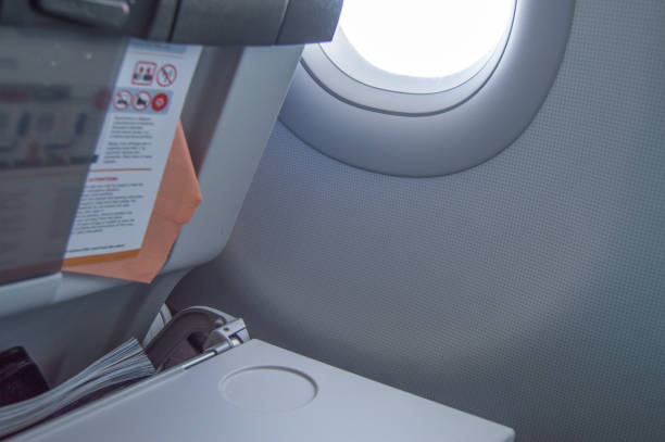 складной стол, инструкции по полету, журнал на переднем сиденье, иллюминатор, концепция полетов и путешествий - private airplane flash стоковые фото и изображения