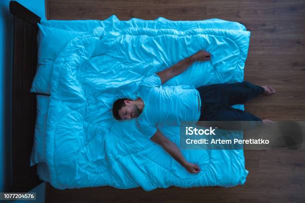 The Man Laying On The Bed View From Above Evening Night Time Stock Photo - Download Image Now