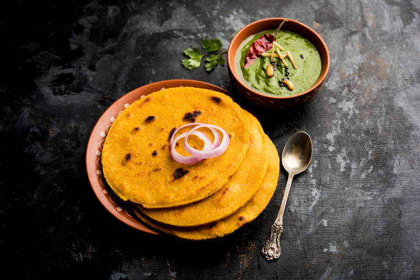istock Makki di roti with sarson ka saag, popular punjabi main course recipe in winters made using corn breads mustard leaves curry. served over moody background. selective focus 1077206102