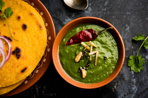 istock Makki di roti with sarson ka saag, popular punjabi main course recipe in winters made using corn breads mustard leaves curry. served over moody background. selective focus 1077206338