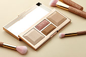 Make up palette and brushes on beige background