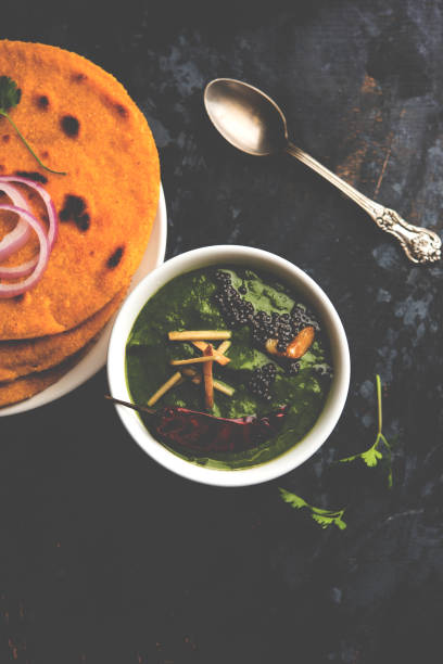 istock Makki di roti with sarson ka saag, popular punjabi main course recipe in winters made using corn breads mustard leaves curry. served over moody background. selective focus 1077207226