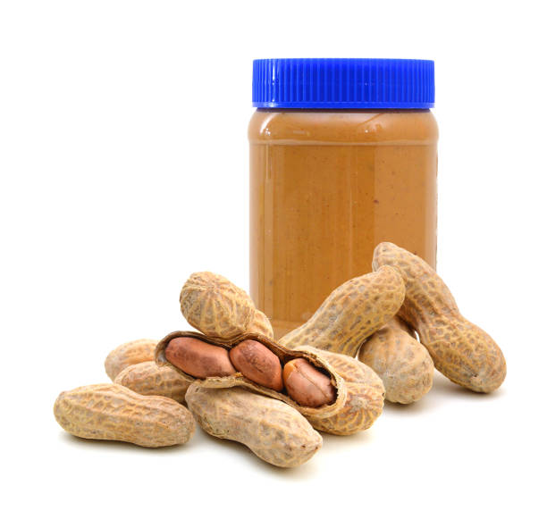 istock Jar of peanut butter and penuts on a white background 1077208660