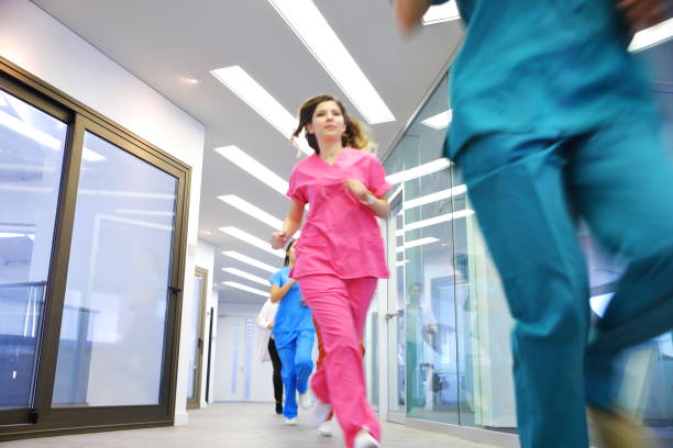 ärzte und krankenschwestern binsen für den notfall im krankenhausflur - surgeon urgency expertise emergency services stock-fotos und bilder