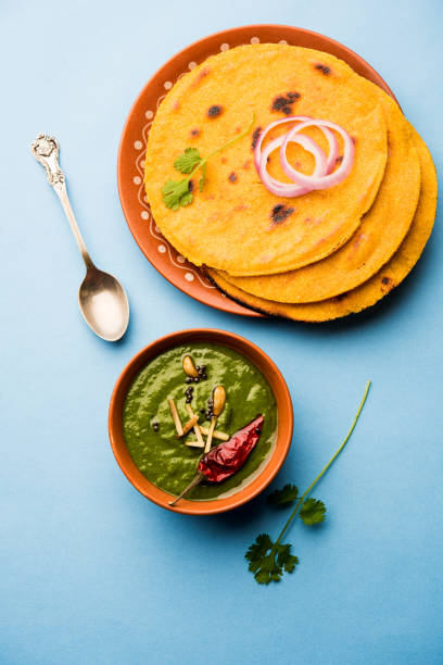 istock Makki di roti with sarson ka saag, popular punjabi main course recipe in winters made using corn breads mustard leaves curry. served over moody background. selective focus 1077209342