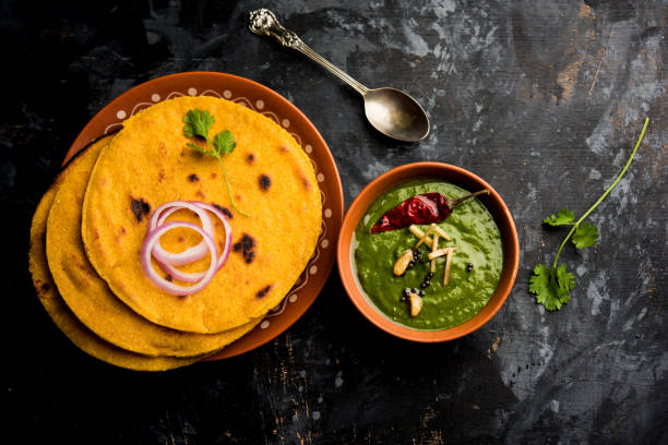 Makki di roti with sarson ka saag, popular punjabi main course recipe in winters made using corn breads mustard leaves curry. served over moody background. selective focus stock photo