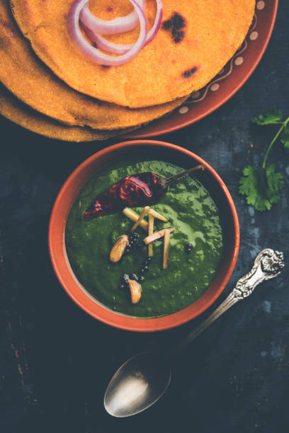 istock Makki di roti with sarson ka saag, popular punjabi main course recipe in winters made using corn breads mustard leaves curry. served over moody background. selective focus 1077209516
