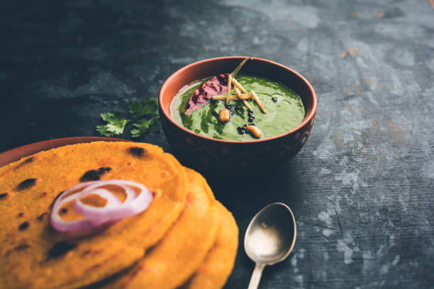 istock Makki di roti with sarson ka saag, popular punjabi main course recipe in winters made using corn breads mustard leaves curry. served over moody background. selective focus 1077209692