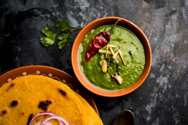 istock Makki di roti with sarson ka saag, popular punjabi main course recipe in winters made using corn breads mustard leaves curry. served over moody background. selective focus 1077209806