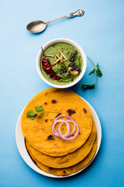 istock Makki di roti with sarson ka saag, popular punjabi main course recipe in winters made using corn breads mustard leaves curry. served over moody background. selective focus 1077212512