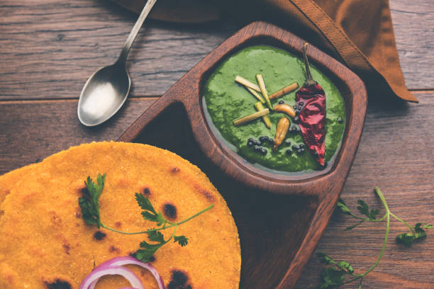 istock Makki di roti with sarson ka saag, popular punjabi main course recipe in winters made using corn breads mustard leaves curry. served over moody background. selective focus 1077212744