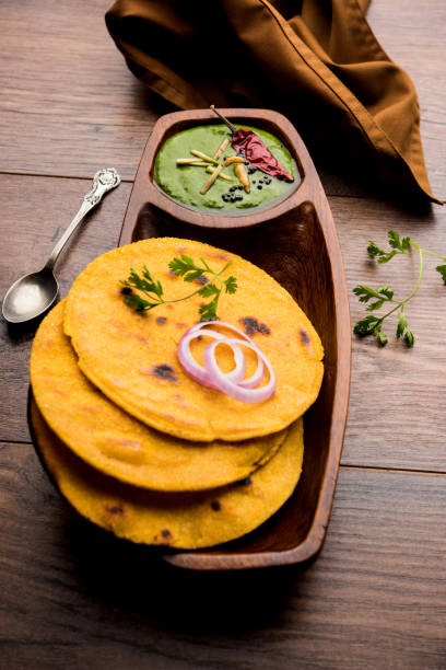 istock Makki di roti with sarson ka saag, popular punjabi main course recipe in winters made using corn breads mustard leaves curry. served over moody background. selective focus 1077213106