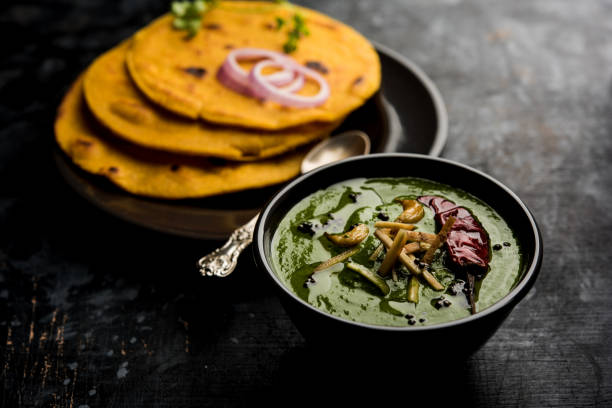 istock Makki di roti with sarson ka saag, popular punjabi main course recipe in winters made using corn breads mustard leaves curry. served over moody background. selective focus 1077215636
