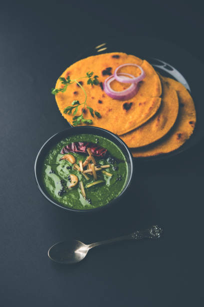 istock Makki di roti with sarson ka saag, popular punjabi main course recipe in winters made using corn breads mustard leaves curry. served over moody background. selective focus 1077216608