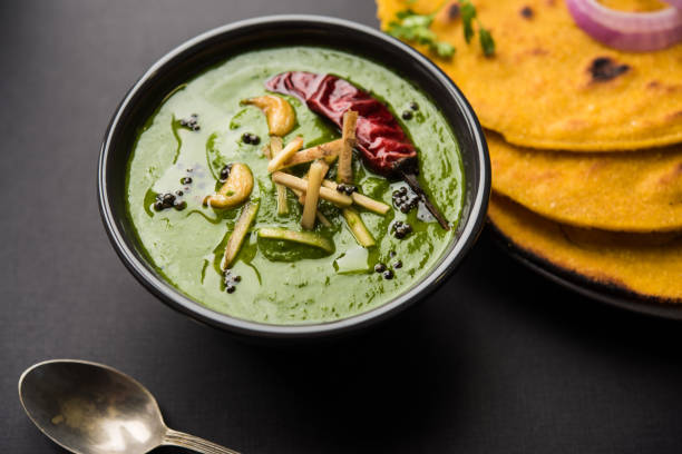 istock Makki di roti with sarson ka saag, popular punjabi main course recipe in winters made using corn breads mustard leaves curry. served over moody background. selective focus 1077216636