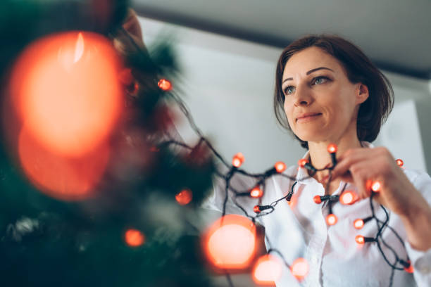 istock Woman decorating Christmas tree 1077218102