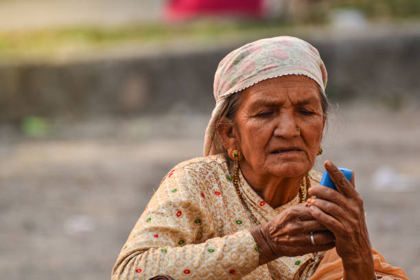 오래 된 여자는 두 손으로 휴대 전화를 확인 하려고 - india traditional culture indigenous culture women 뉴스 사진 이미지