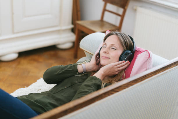 istock Woman relaxing with headphones on sofa 1077227608
