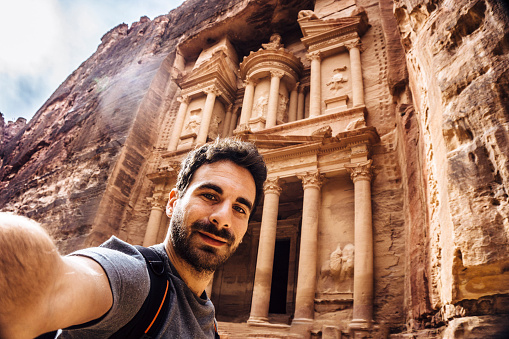 Young traveller taking a selfie in front of the magnificent Treasury of Petra, Jordan