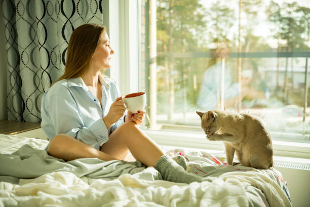 istock Woman sitting at home a bed by the window 1077229272