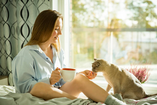 istock Woman sitting at home a bed by the window 1077229278