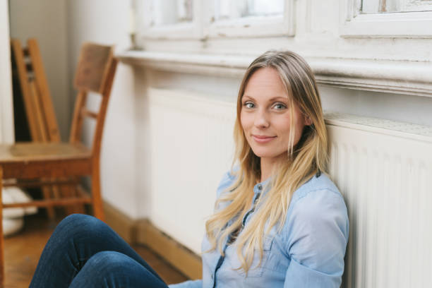 istock Young blond woman relaxing against a radiator 1077229376