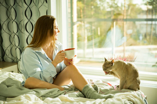 istock Woman sitting at home a bed by the window 1077229690